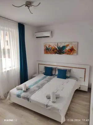 a bedroom with a large bed with blue pillows at Вила TIMeS in Kiten