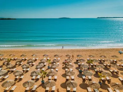 a group of umbrellas and chairs on a beach at Апартамент на къмпинг Градина in Chernomorets