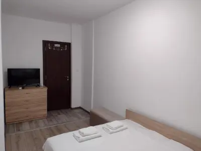 a small bedroom with a bed and a television at Апартамент на къмпинг Градина in Chernomorets