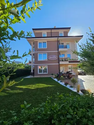 a building with a lawn in front of it at Villa Yanevi in Ravda