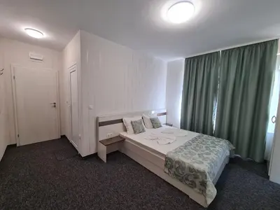 a bedroom with a bed and a large window at Villa Yanevi in Ravda