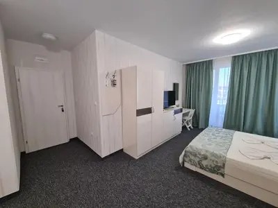 a hotel room with a bed and a television at Villa Yanevi in Ravda