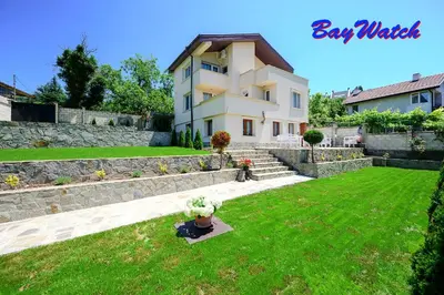 a house with a green yard with a potted plant at Villa Baywatch in Galata