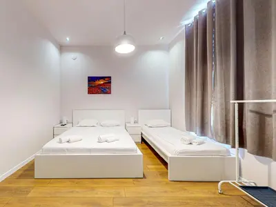 a bedroom with two beds and a window at Markoni 1 in Burgas City