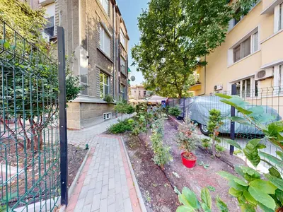 a garden in front of a building with a fence at Markoni 1 in Burgas City