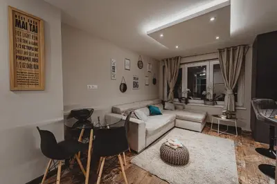 a living room with a couch and a table and chairs at Sunset Apartment in Pomorie