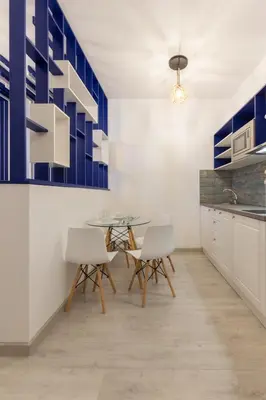 a kitchen with a glass table and white chairs at Seaman's house in Burgas City