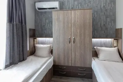 a bedroom with two beds and a cupboard at BOLERO Suites in Varna City