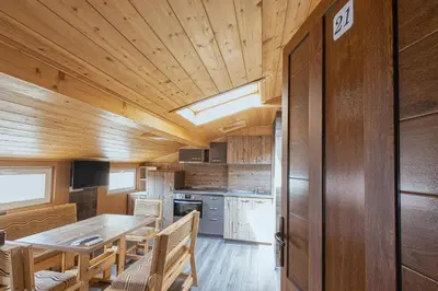 a kitchen and dining room with a wooden ceiling at BOLERO Suites in Varna City