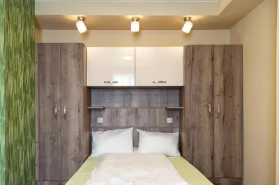 a bedroom with a wooden headboard and a bed at BOLERO Suites in Varna City
