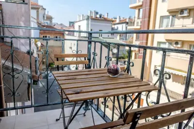 a wooden table and chairs on a balcony at Charisma apt - lux at top city center in Varna City