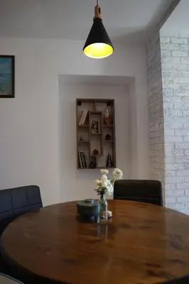 a dining room table with chairs and aendant light at Guest house Dimant in Burgas City