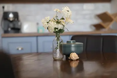 a vase of flowers sitting on a table with a bowl at Guest house Dimant in Burgas City