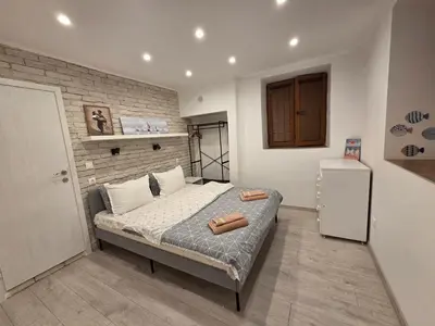 a bedroom with a bed and a brick wall at Guest house Dimant in Burgas City
