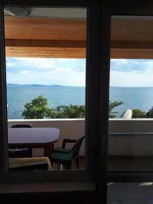a view of the ocean from the balcony of a house at Стаи за гости WEST in Pomorie
