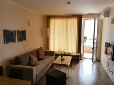 a living room with a couch and a table at Апартамент Б003 в Обзор Бийч Резорт- море пред прозореца, плаж пред вратата !!! in Obzor