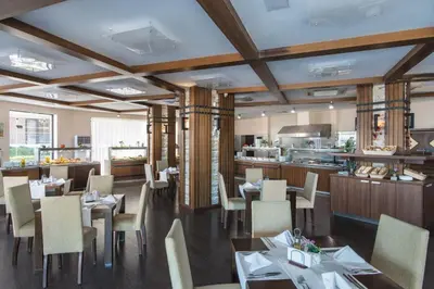 a restaurant with tables and chairs and a kitchen at Апартамент Б003 в Обзор Бийч Резорт- море пред прозореца, плаж пред вратата !!! in Obzor