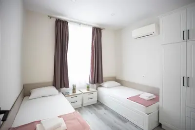a bedroom with two beds and a window at Апартамент за гости Стела in Burgas City