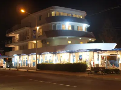 a building with lights in front of it at night at Семеен Хотел 