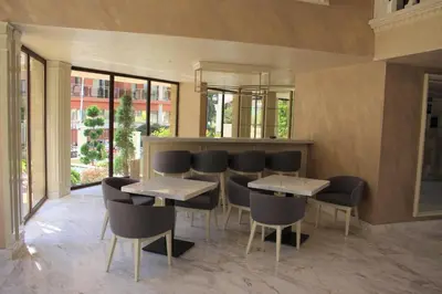a restaurant with two tables and chairs and windows at Valencia Gardens Luxury Studios in Nesebar