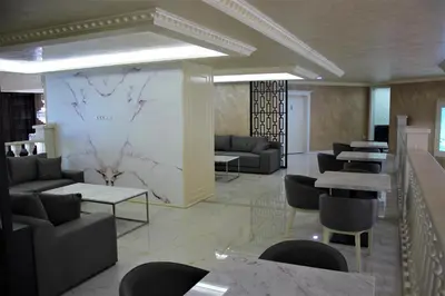 a lobby with couches and tables and a marble wall at Valencia Gardens Luxury Studios in Nesebar