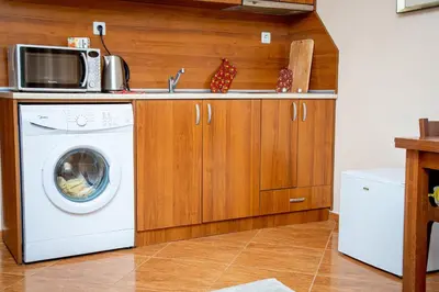 a kitchen with a washing machine and a microwave at Helios Studio in a Complex in St Vlas by Flat Mаnаger in Sveti Vlas