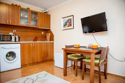 a kitchen with a table and a washing machine at Helios Studio in a Complex in St Vlas by Flat Mаnаger in Sveti Vlas