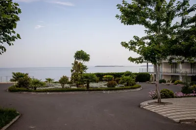 a driveway in front of a building with the ocean in the background at Helios Studio in a Complex in St Vlas by Flat Mаnаger in Sveti Vlas