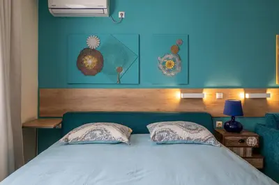 a bed with a blue headboard with two pillows at Turquoise in Pomorie