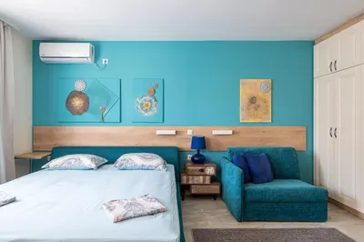 a bedroom with a bed and a blue wall at Turquoise in Pomorie