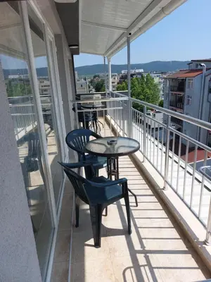 a balcony with a table and chairs on a building at Къща за гости WEST in Sunny Beach
