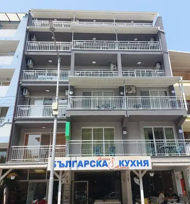 an apartment building with a sign in front of it at Къща за гости WEST in Sunny Beach