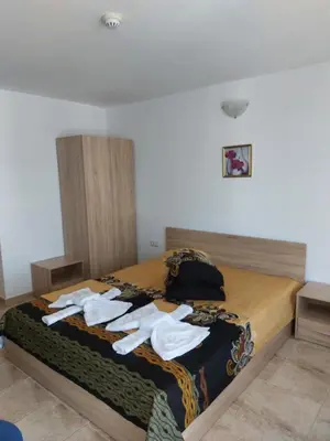a bedroom with a bed with white towels on it at Къща за гости WEST in Sunny Beach