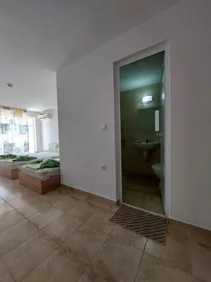 a room with a bathroom with a bed and a shower at Къща за гости WEST in Sunny Beach