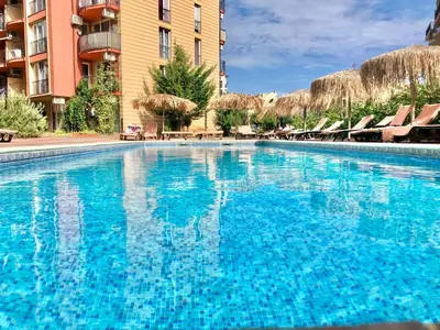 a large blue swimming pool in front of a building at Sunny View Central - Menada Apartments in Sunny Beach