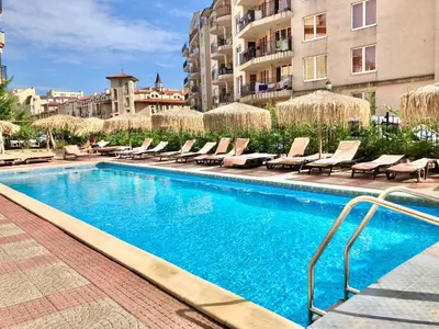 a swimming pool with chaise lounges and chairs at Sunny View Central - Menada Apartments in Sunny Beach