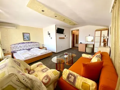 a hotel room with two beds and a couch at Family Hotel The Golden fish in Sozopol