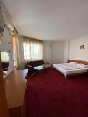 a room with a bed and a couch and a table at Family Hotel The Golden fish in Sozopol