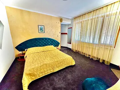 a bedroom with a bed and a yellow bedspread at Family Hotel The Golden fish in Sozopol