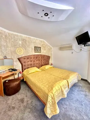 a bedroom with a large bed with a yellow bedspread at Family Hotel The Golden fish in Sozopol