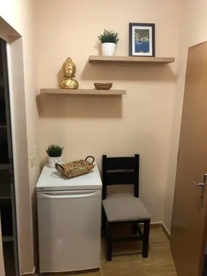 a small kitchen with a chair and a refrigerator at Paradise Dreams apartment in Sveti Vlas
