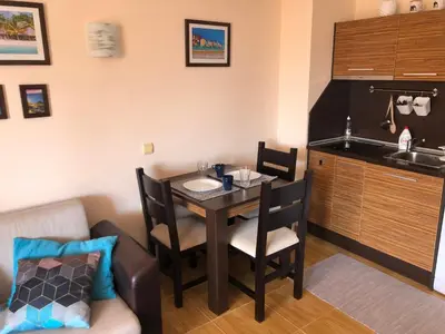 a small kitchen and dining room with a table and a couch at Paradise Dreams apartment in Sveti Vlas