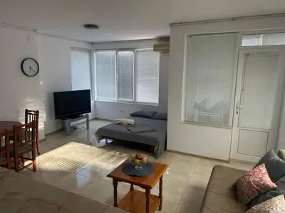 a living room with a couch and a table at Апартамент Енигма in Sveti Vlas