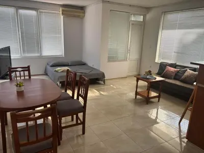 a living room with a table and a couch at Апартамент Енигма in Sveti Vlas