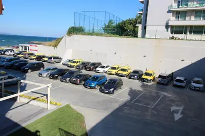 a parking lot full of cars parked next to a building at PARADISO 'В' 408 Private Studio Nessebar in Nesebar