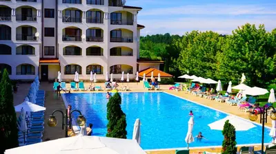 a hotel with a swimming pool in front of a building at Апартамент Сънрайз Обзор - Apartment Sunrise Obzor in Obzor