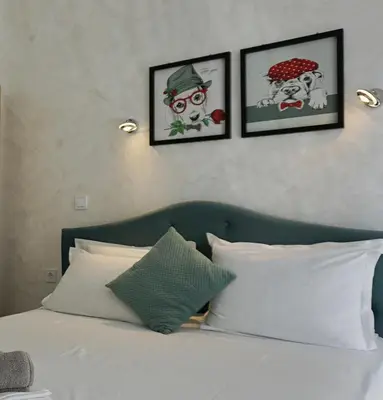 a bedroom with a bed with three pictures on the wall at Апартаменти Атеа на плажа - Apartments Atea on the beach in Obzor