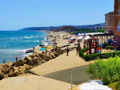 a beach with a bunch of people and the ocean at Апартаменти Атеа на плажа - Apartments Atea on the beach in Obzor