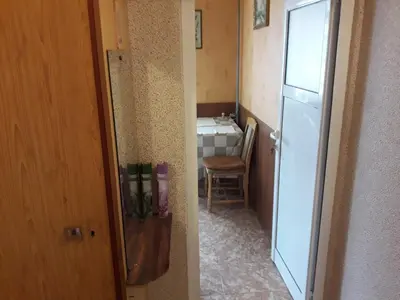 a small kitchen with a white refrigerator and a table at Удобство in Burgas City