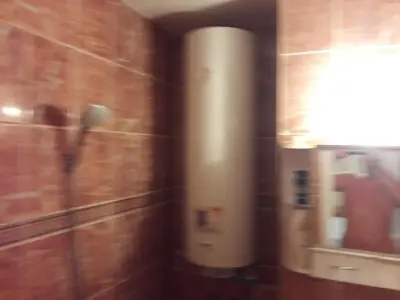 a bathroom with a white heater on the wall at Удобство in Burgas City